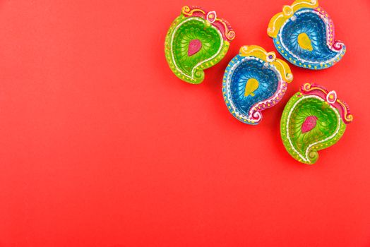 Happy Diwali Day, Flat lay top view Colorful Clay Diya lamps on red background and copy space for your text