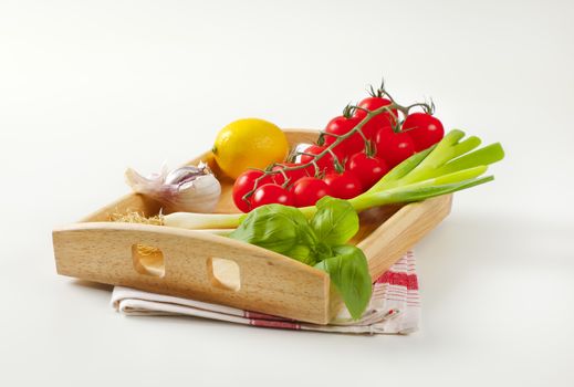 Fresh vegetables and lemon on wooden serving tray