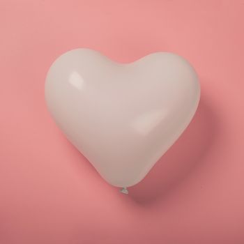 Happy valentines day greetings heart shaped white balloon on pink paper background