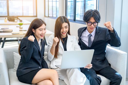 A group of 3 businessmen are happy in front of the computer.