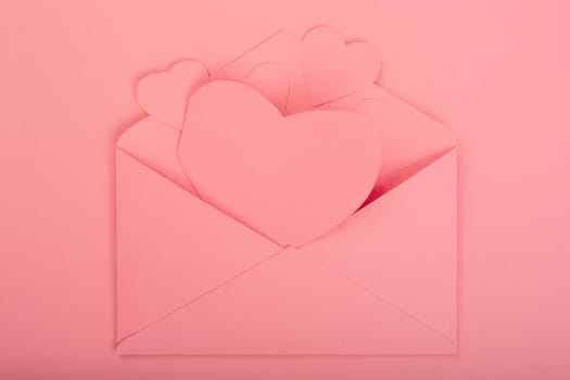 Pink love letter and paper hearts on pink background with copy space for text