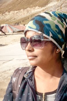 Front Side portrait of young adult beautiful woman (asian and indian ethnicities) with smart casual look headscarf and sunglasses looking away isolated from nature background. Headshot Close up.
