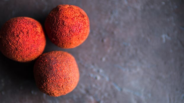 Red homemade truffle coated dry beet powder on dark background. Copy space right for text or design, banner. Top view or flat lay