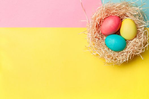 Easter concept. Colorful eggs on bright colorful background with copy space for text. Top down view or flat lay