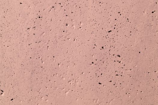 The pink concrete wall. The wall is textured.