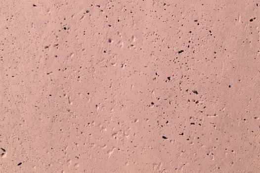 The pink concrete wall. The wall is textured.