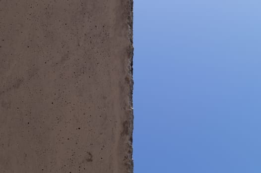 The wall and blue sky crossed the line in center. Abstract photo.