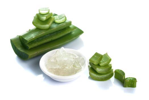 Slices of Aloe Vera leave and Aloe Vera gel in a bowl on a white background. Aloe Vera is a very useful herbal medicine for skin care and hair care.