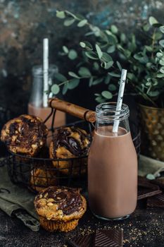 Chocolate milkshake in the glass jar and homemade muffins with hazelnut paste