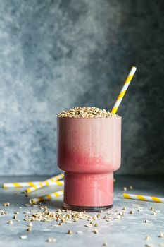 Berry smoothie in glass on gray rustic background, healthy food for breakfast