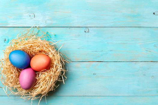 Easter concept. Colorful eggs on blue wooden background with copy space for text. Top down view or flat lay