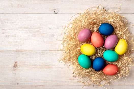 Easter concept. Colorful eggs on white wooden background with copy space for text or design. Top down view or flat lay