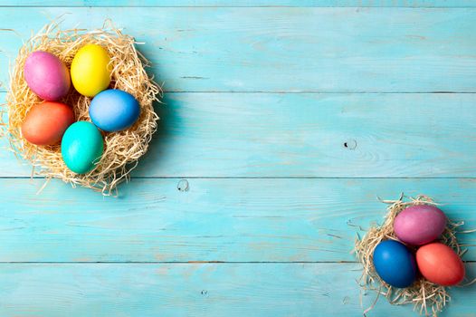 Easter concept. Colorful eggs on blue wooden background with copy space for text. Top down view or flat lay