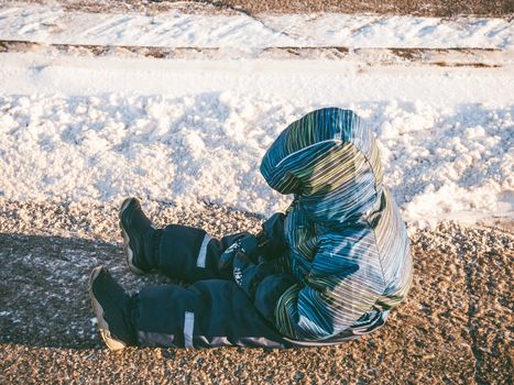 Upset little baby boy sitting on asphalt road. Children's moods, bad behavior, obedience, emper tantrum concept. Copy space for text.