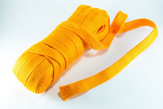 Orange rope rolls flat on white background.