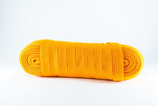 Orange rope rolls flat on white background.