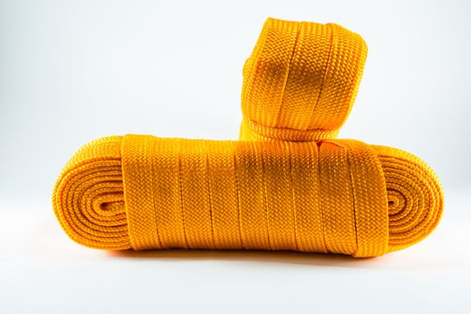 Orange rope rolls flat on white background.