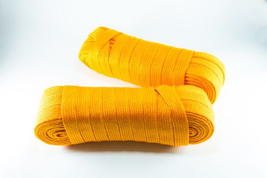 Orange rope rolls flat on white background.