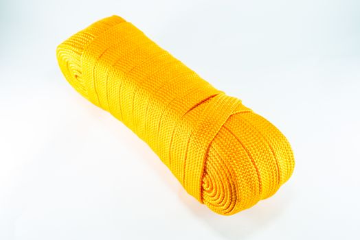 Orange rope rolls flat on white background.