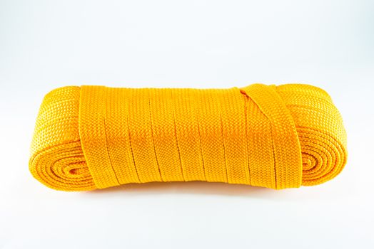 Orange rope rolls flat on white background.