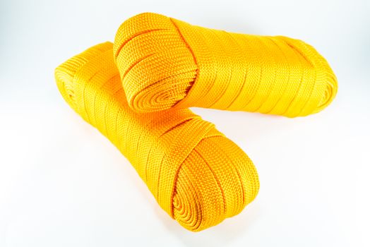 Orange rope rolls flat on white background.
