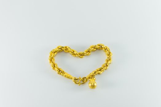 Gold bracelet on white background. heart shape.