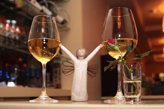 Romantic two glasses with wine and angel