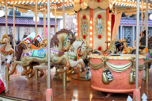 Children's carousel with horses at the fair