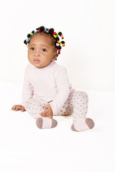 Portrait of nice baby sitting and looking at the camera on a white background
