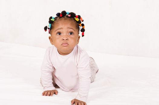 Pretty baby creeping looking up isolated on white background