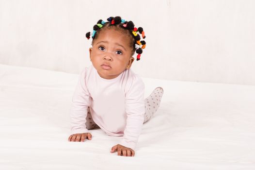Pretty baby creeping looking up isolated on white background