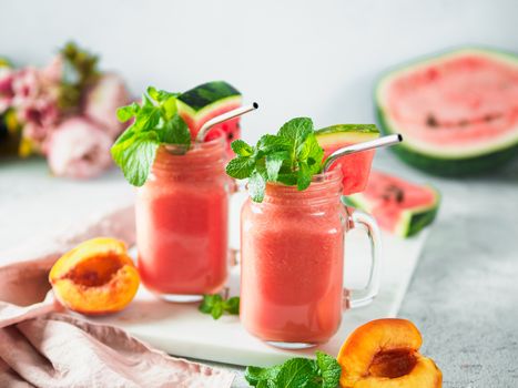 Freshly Blended Watermelon and Peach Smoothies in mason jar and metal straw