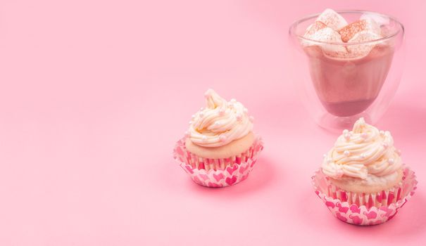 Valentine day love cupcake decorated with cream and hot chocolate on pink background with copy space for text