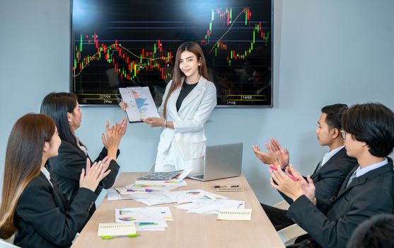 A group of business people meeting and applauding the leader