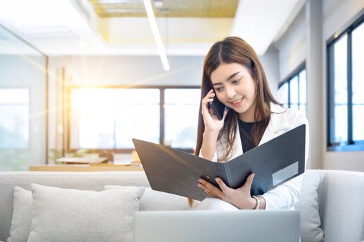 Business women holding files and talking on the phone