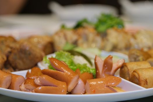 The Sliced on a plate in the form of ham sausage and vegetables in a restaurant, appetizer.