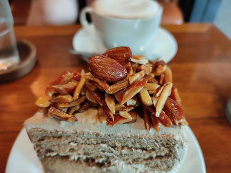 The Homemade Almond cake slice decorated on white plate, selected focus