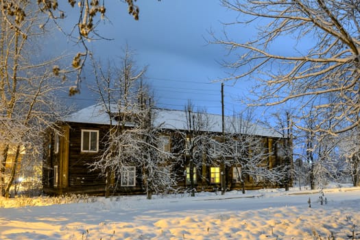 Nocturnal faces and an old house in night illumination under a dark sky.