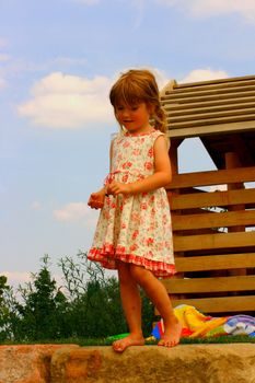 Blond girl barefoot in the summer dress