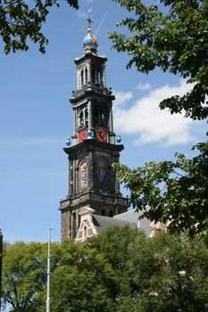 a church spire seen through trees, with blue sky