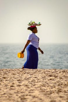 GAMBIE, BIJILO - 05 January 2020;Woman selling fruit in a basket on Bijilo beach in
Gambia