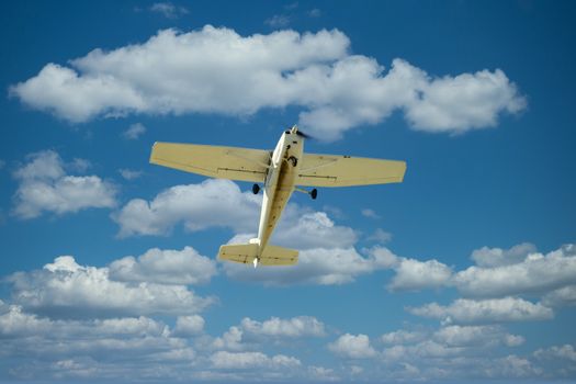 A small prop plane flying overhead against blue sky