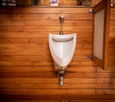 Clean White urinal in teak wood bath room, Beautiful bath room