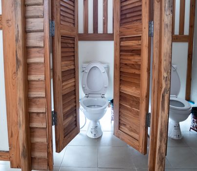 Clean White toilet in teak wood bath room, Beautiful rest room