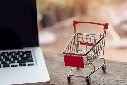 Shopping online concept - Empty shopping cart or trolley on a laptop keyboard. Shopping service on The online web. offers home delivery.
