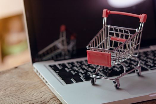 Shopping online concept - Empty shopping cart or trolley on a laptop keyboard. Shopping service on The online web. offers home delivery.
