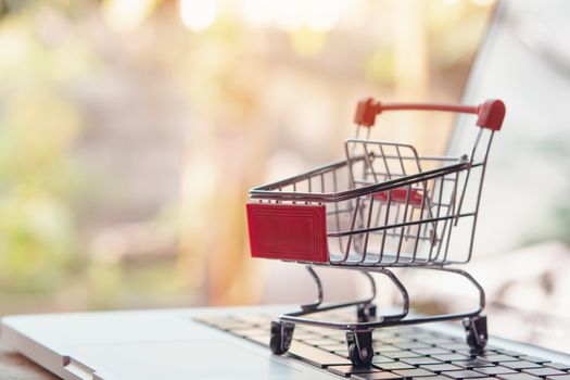 Shopping online concept - Empty shopping cart or trolley on a laptop keyboard. Shopping service on The online web. offers home delivery.
