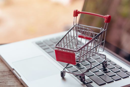 Shopping online concept - Empty shopping cart or trolley on a laptop keyboard. Shopping service on The online web. offers home delivery.
