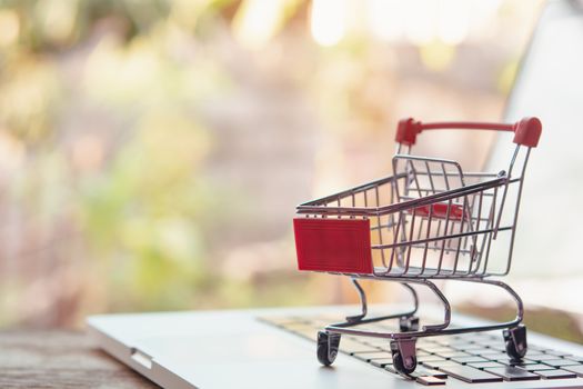Shopping online concept - Empty shopping cart or trolley on a laptop keyboard. Shopping service on The online web. offers home delivery.
