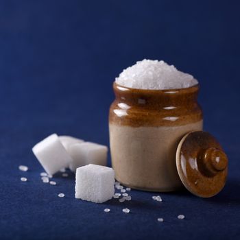 Sugar. white granulated sugar and refined sugar on a blue background